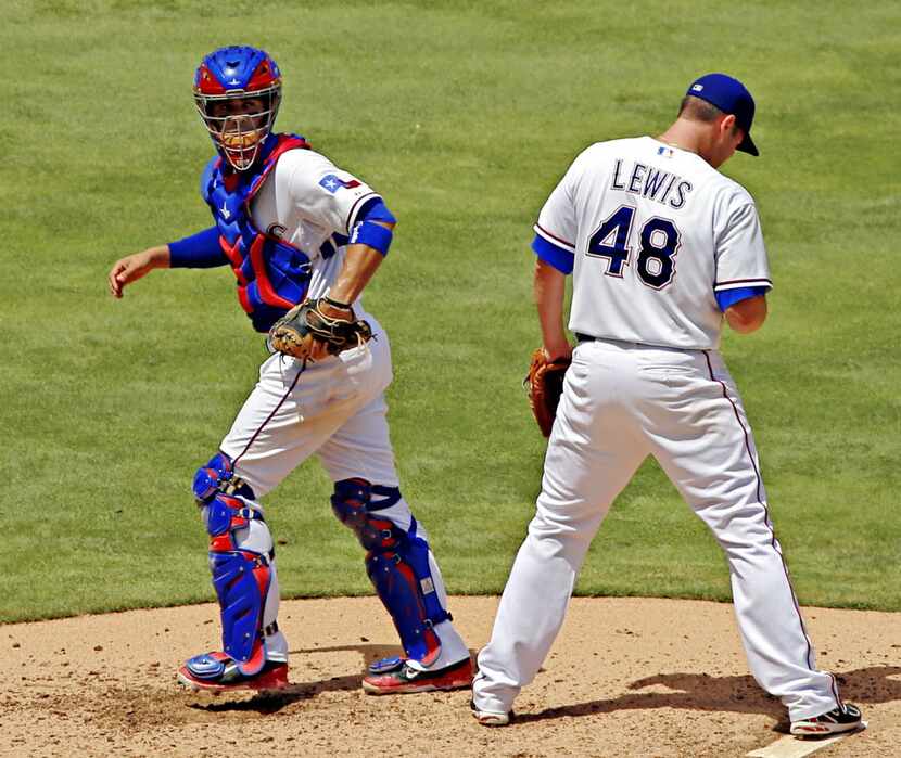 Texas Rangers catcher Robinson Chirinos (left) heads back to the plate after trying to talk...