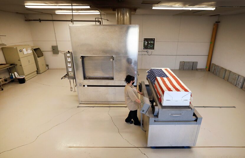 Loni Varela moves a container bearing a Navy veteran to a chamber for cremation at Simple...