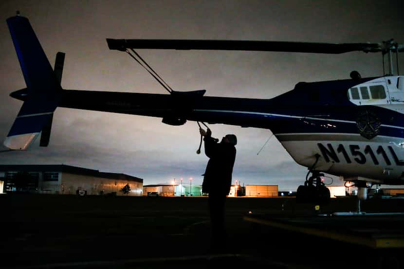 Senior Cpl. Mark Colborn ties down the main rotor blade of one of the unit's helicopters...