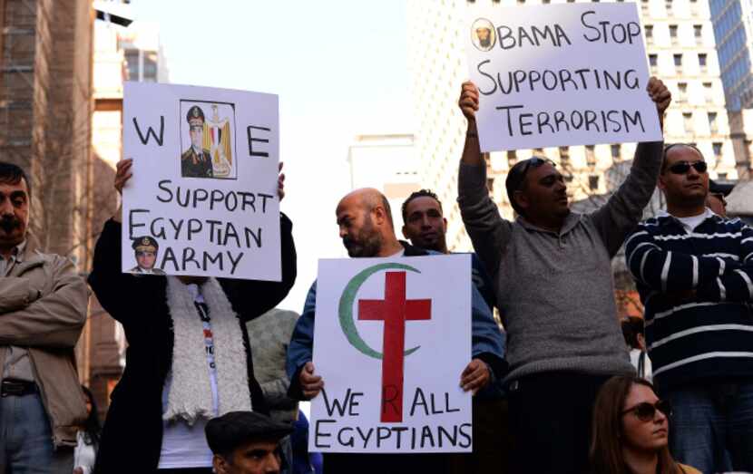 Protestors display placards during a protest against Egypt's ousted president Mohamed...