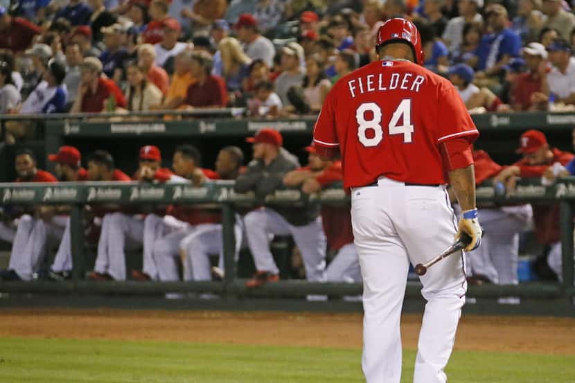 Texas designated hitter Prince Fielder heads back to the dugout after striking out in the...