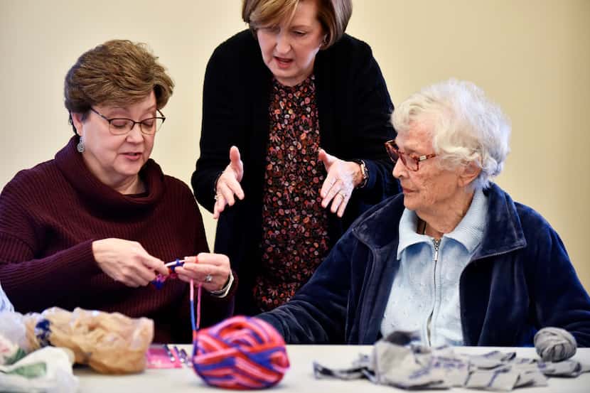 Kay McCall (from left), 62, learns to crochet from Kristi Jenkins, 63, and resident Emma...