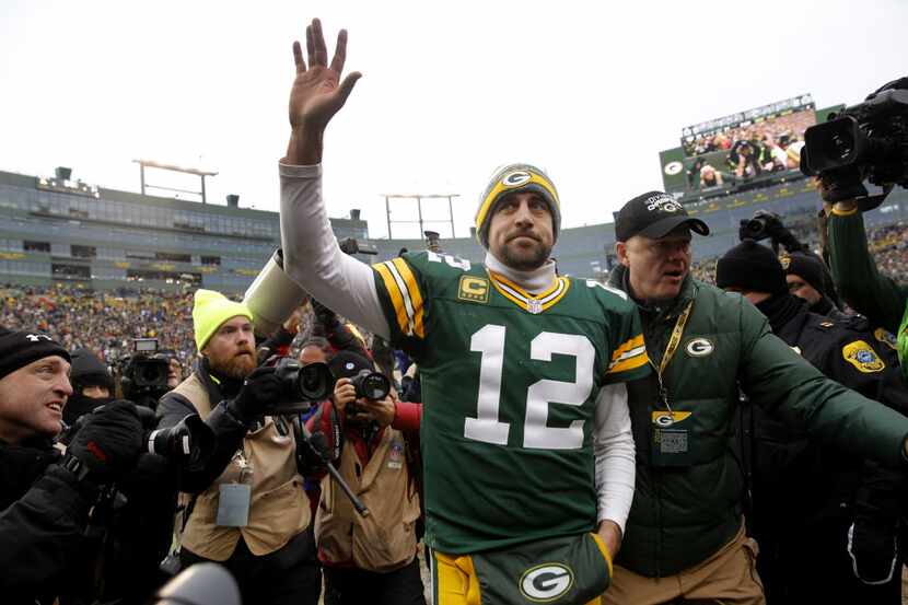 Green Bay Packers quarterback Aaron Rodgers (12) waves tot he fans as he elves the field...