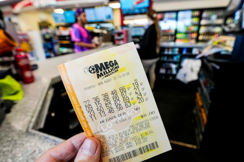 FILE - A Mega Millions ticket is seen as a person makes a purchase inside a convenience...