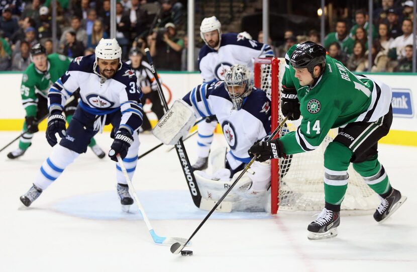 DALLAS, TX - JANUARY 15: Jamie Benn #14 of the Dallas Stars skates the puck in front of...