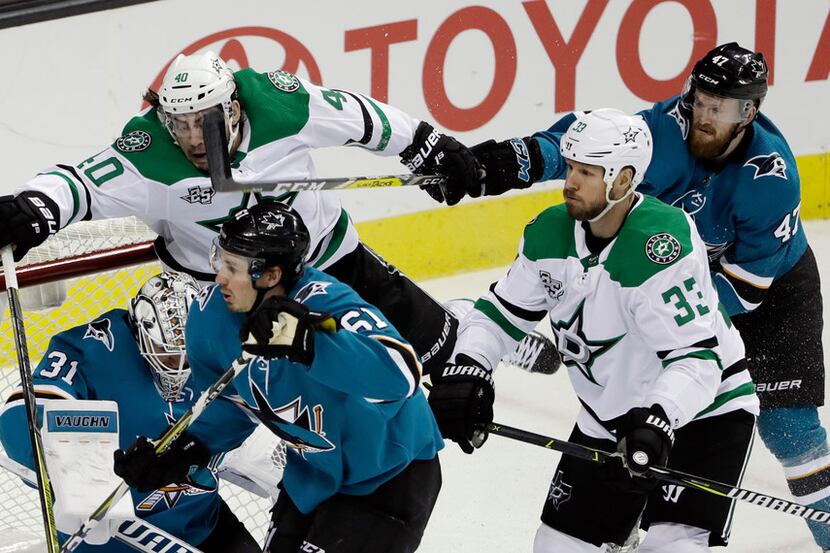 Dallas Stars' Remi Elie, top center, collides with San Jose Sharks goaltender Martin Jones...