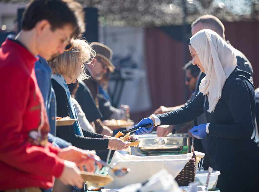 Members of Break Bread, Break Borders serve Iraqi and Syrian dishes and barbecue during an...