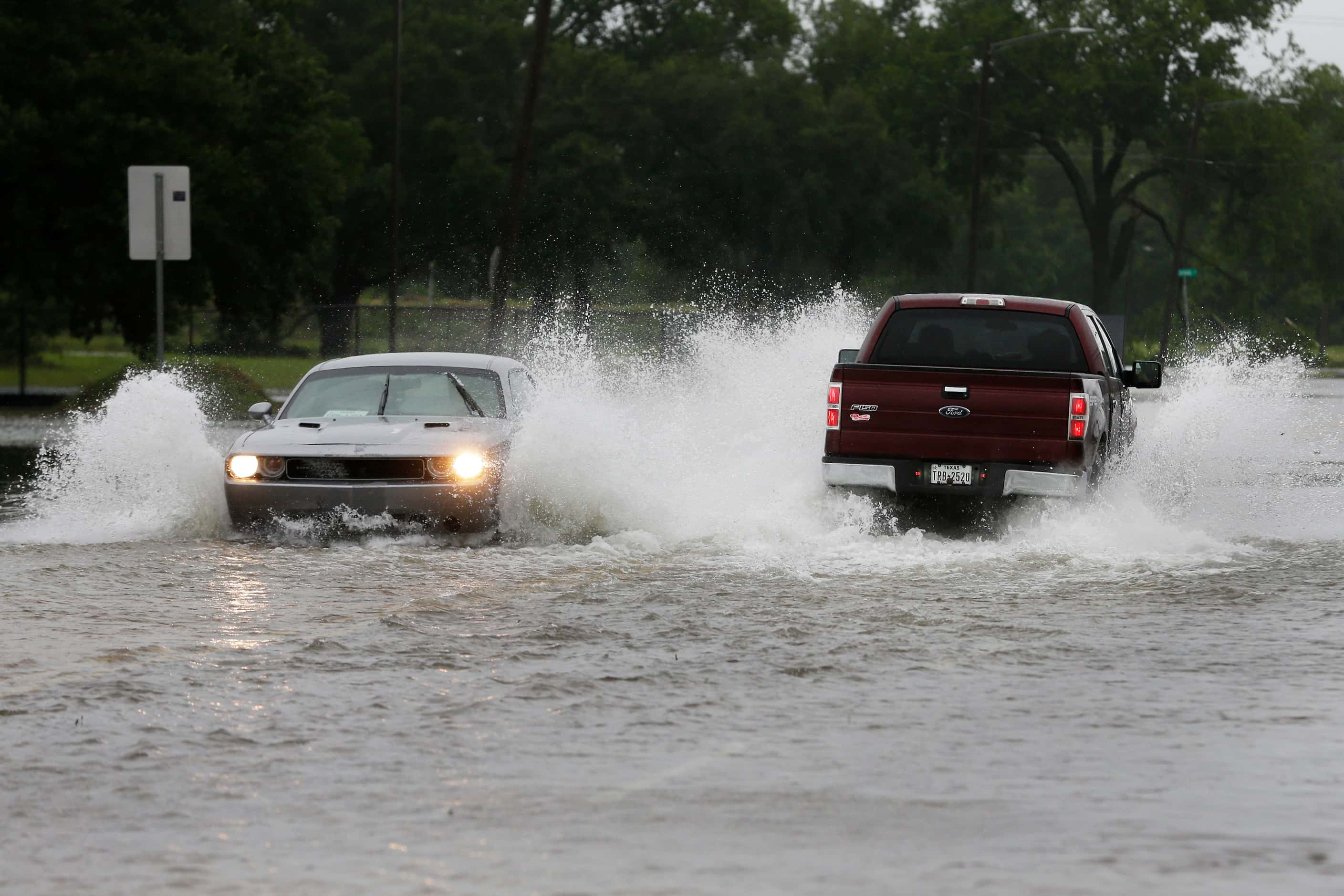 Motorists drive through flood waters on Reading Rd. during a lull in the wind and rain as...