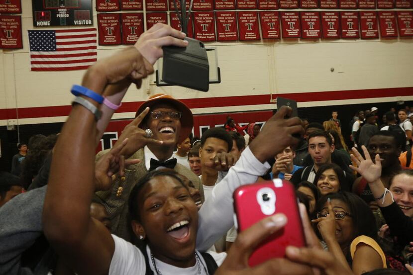 Students swarmed Euless Trinity basketball player Myles Turner, (with orange hat) after he...