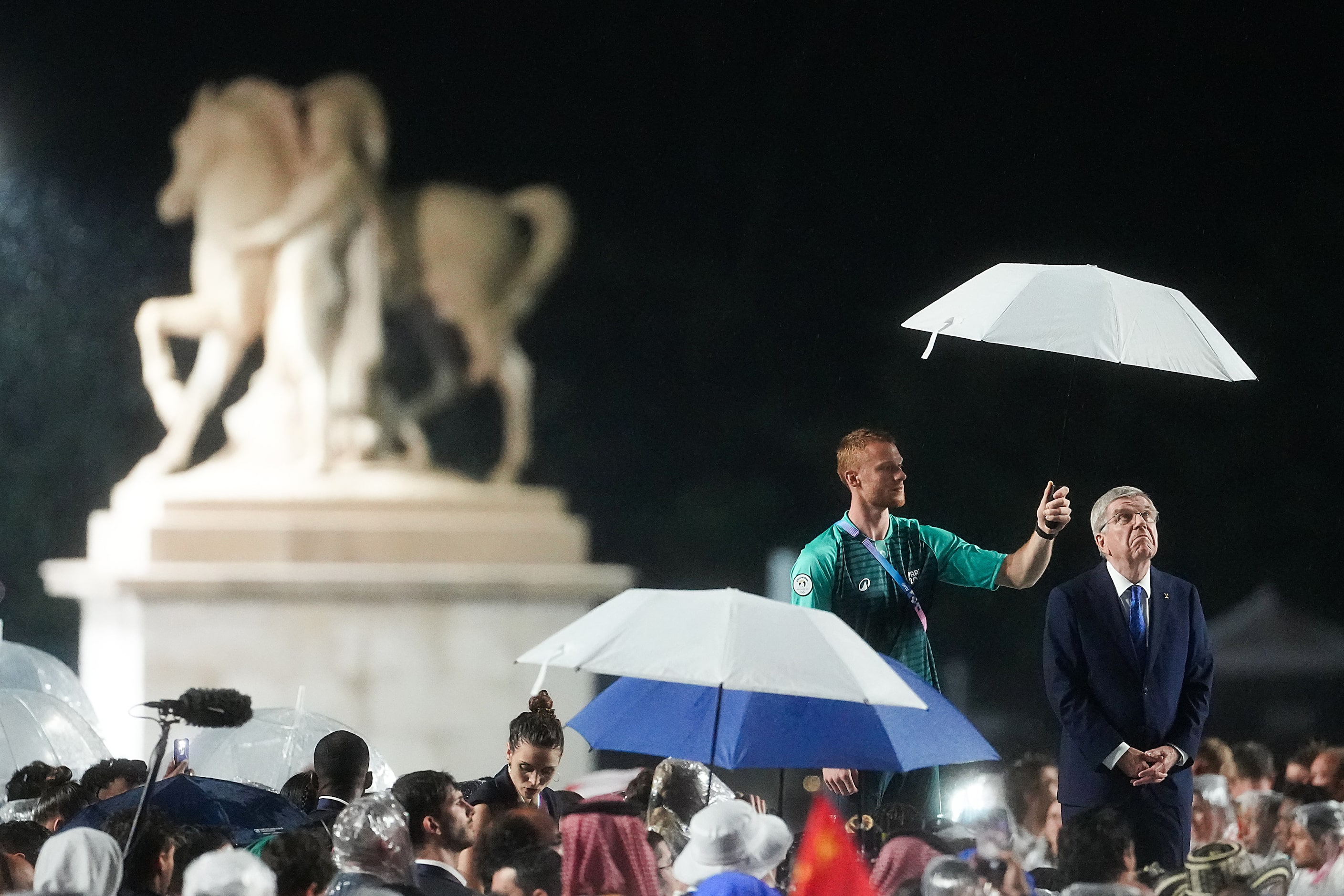 Thomas Bach, President of the International Olympic Committee, looks up from under an...