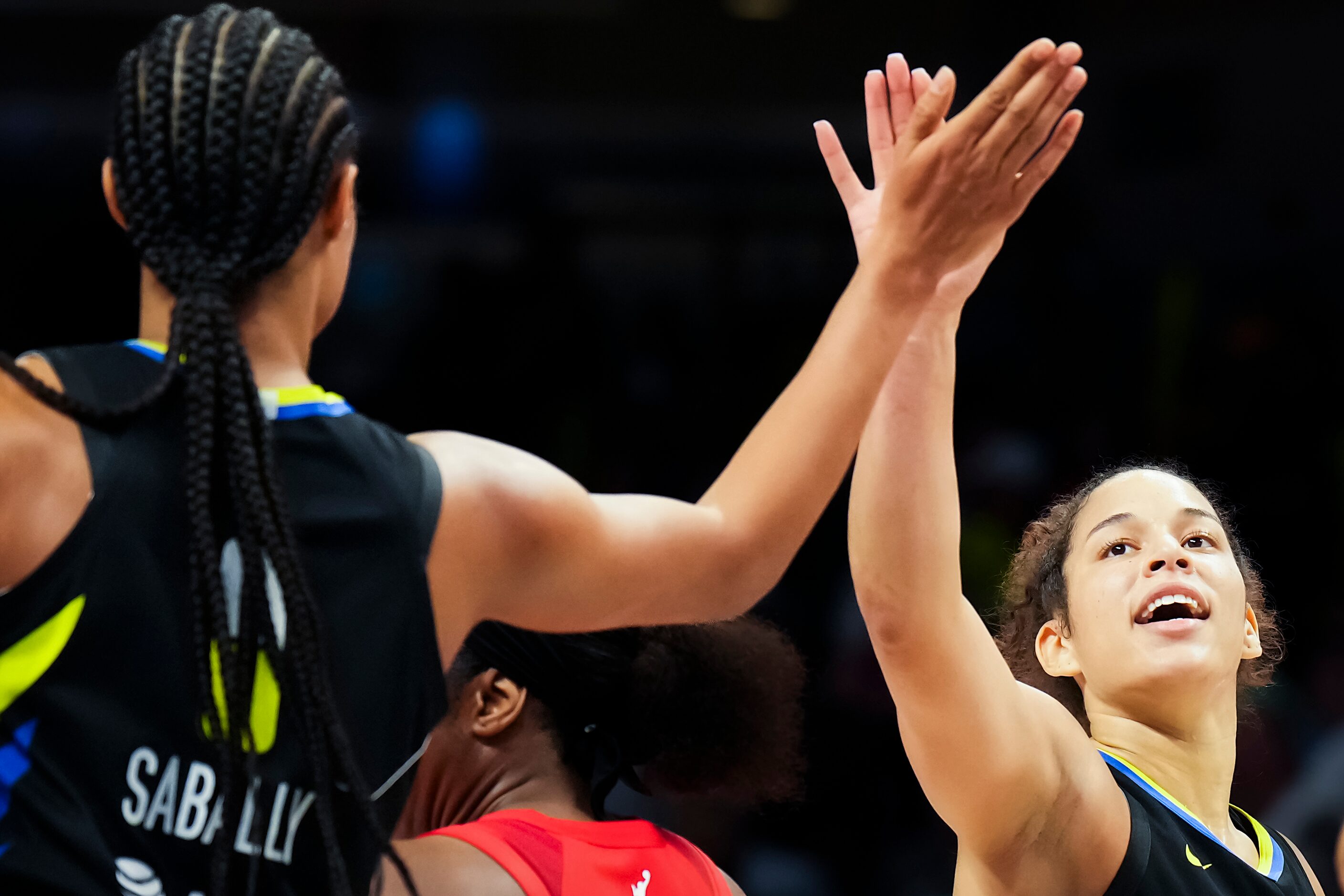 Dallas Wings guard Veronica Burton (12) celebrates with forward Satou Sabally (0) during the...