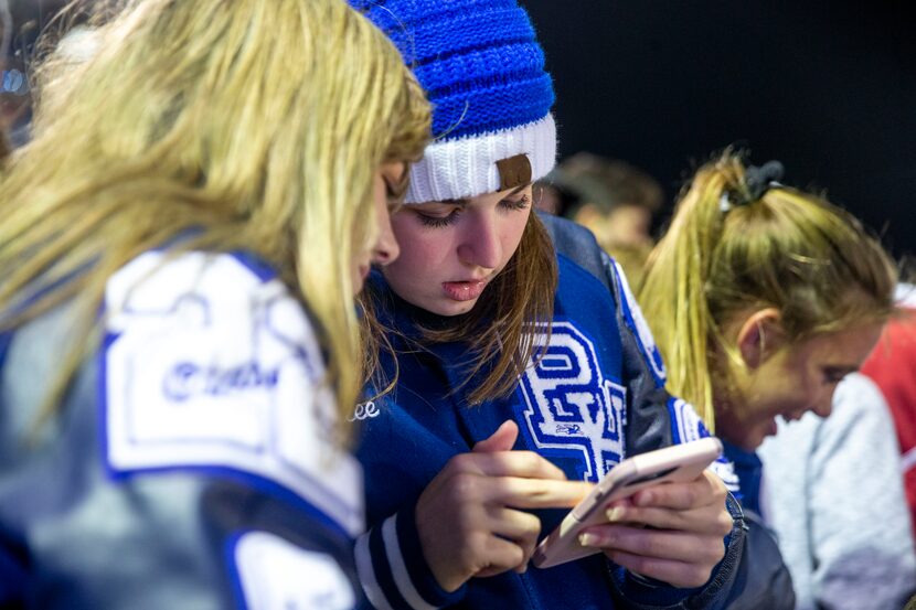 Demi Trammell, 16, shows Emalee Maze 15, both of Baytown, a photo on her phone during a...