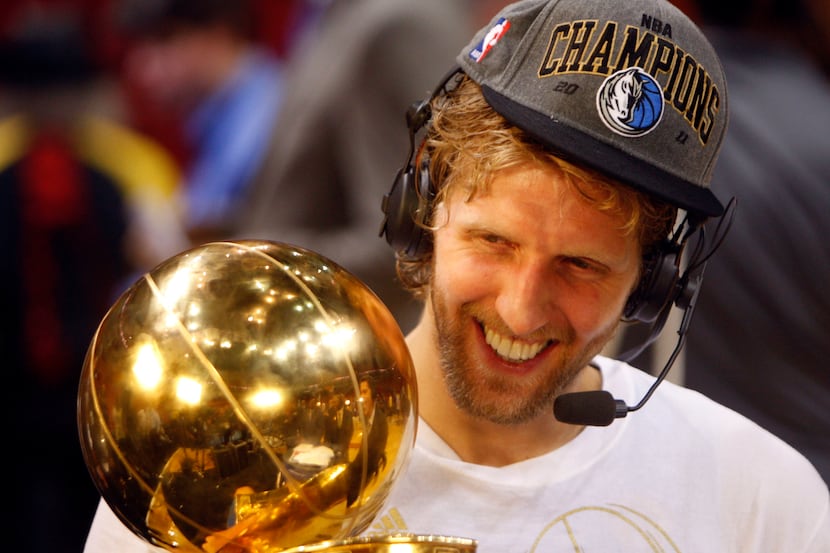 Dallas' Dirk Nowitzki smiles while holding the Larry O'Brien NBA Championship trophy 