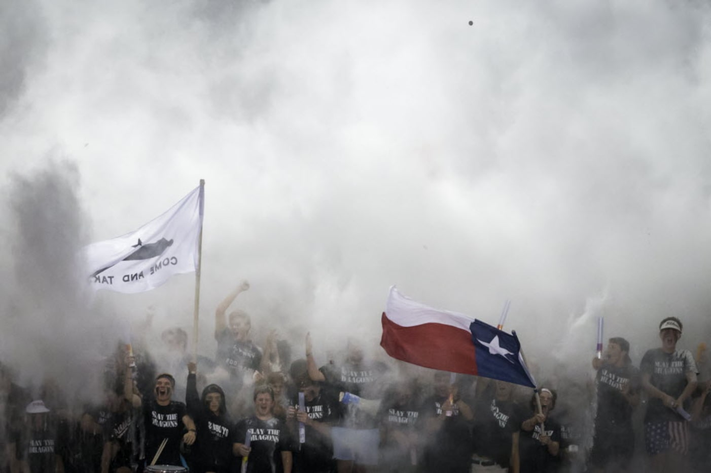 Coppell fans disappear into a cloud of powder as they cheer beginning of a high school...