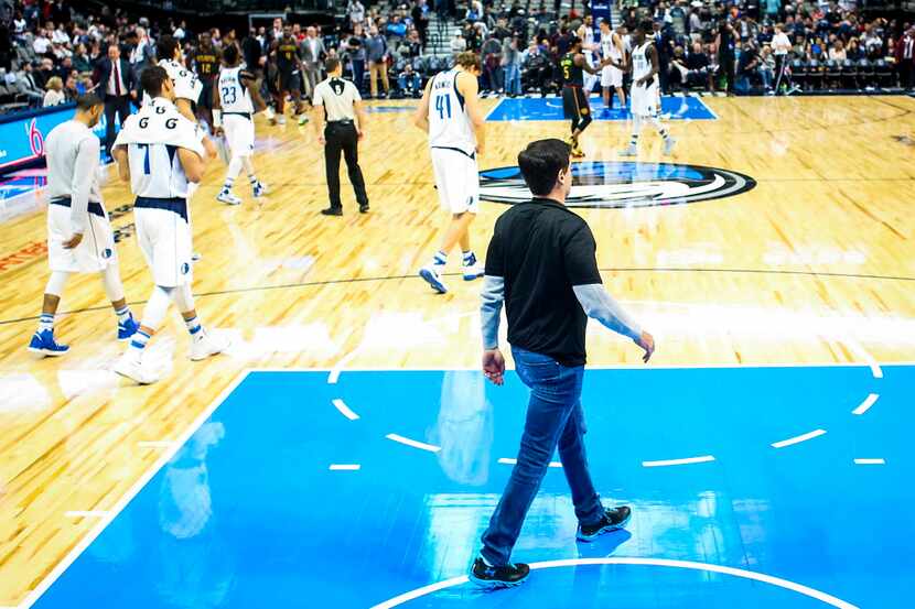 Dallas Mavericks owner Mark Cuban walks off the floor with his team after a loss to the...