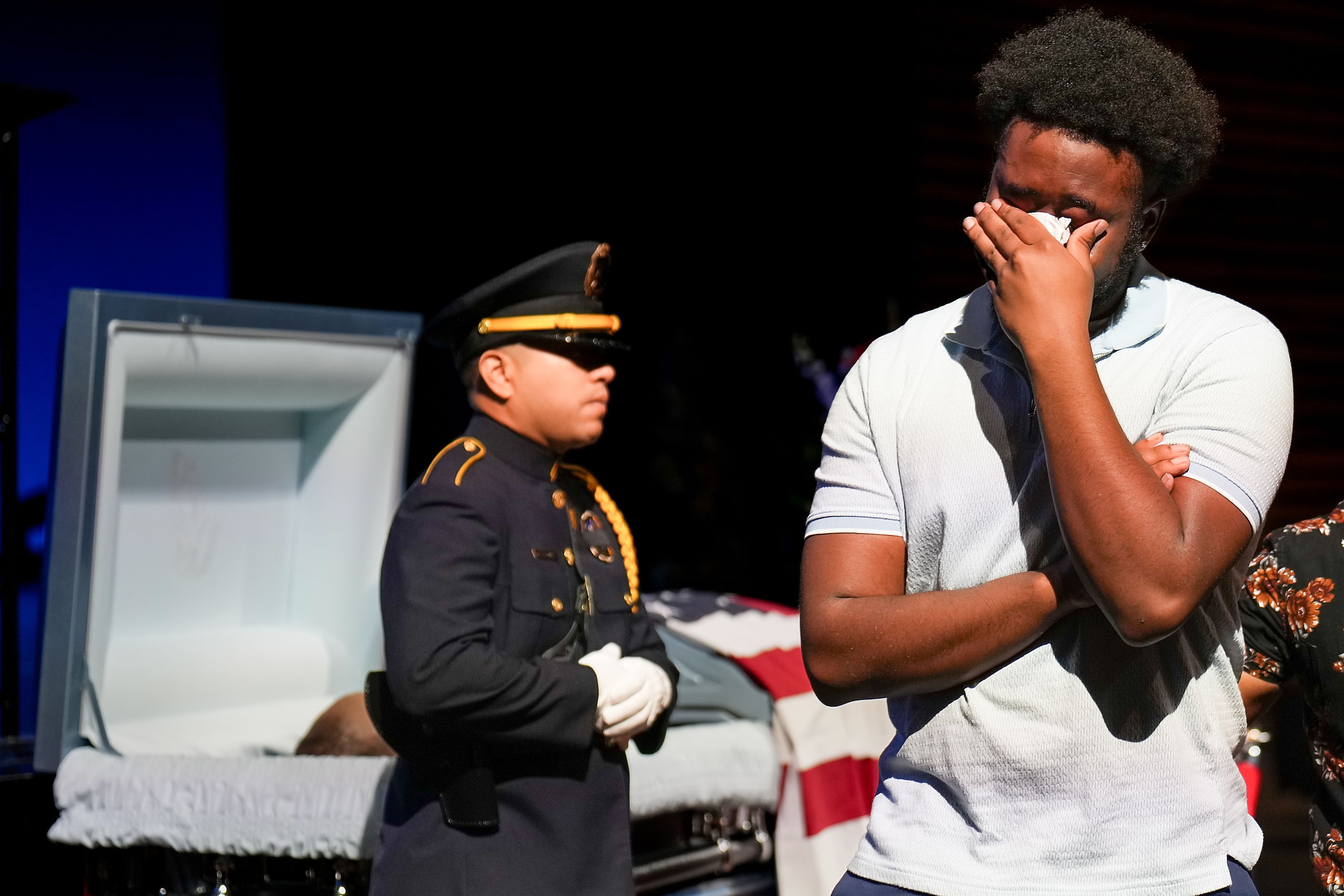 A mourner wipes away tears after visiting the casket of Dallas police officer Darron Burks...