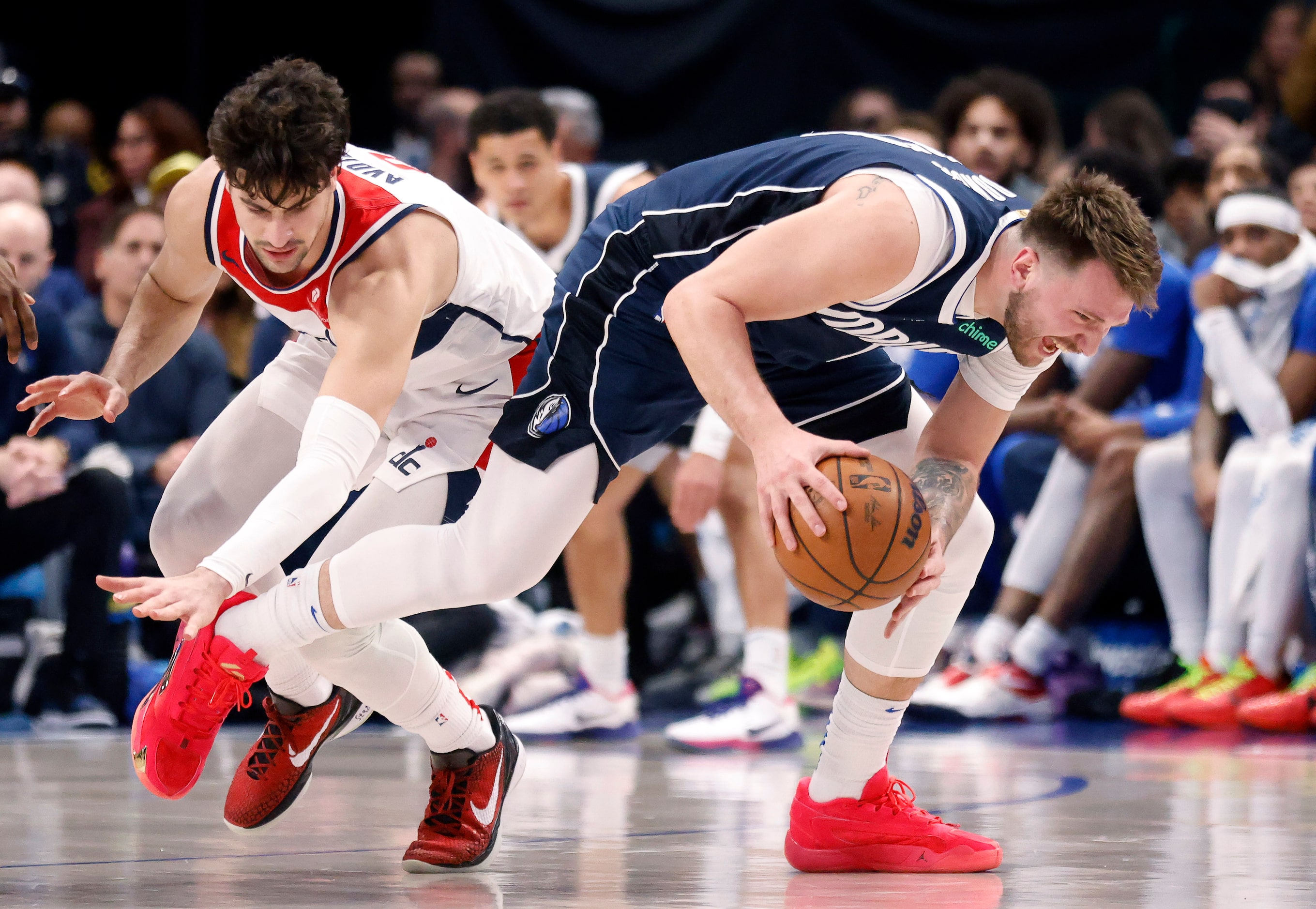 Dallas Mavericks guard Luka Doncic (77) goes to the floor to recover the ball as he’s hit by...