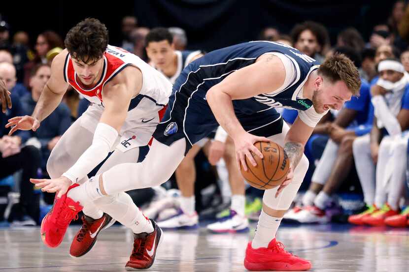 Dallas Mavericks guard Luka Doncic (77) goes to the floor to recover the ball as he’s hit by...