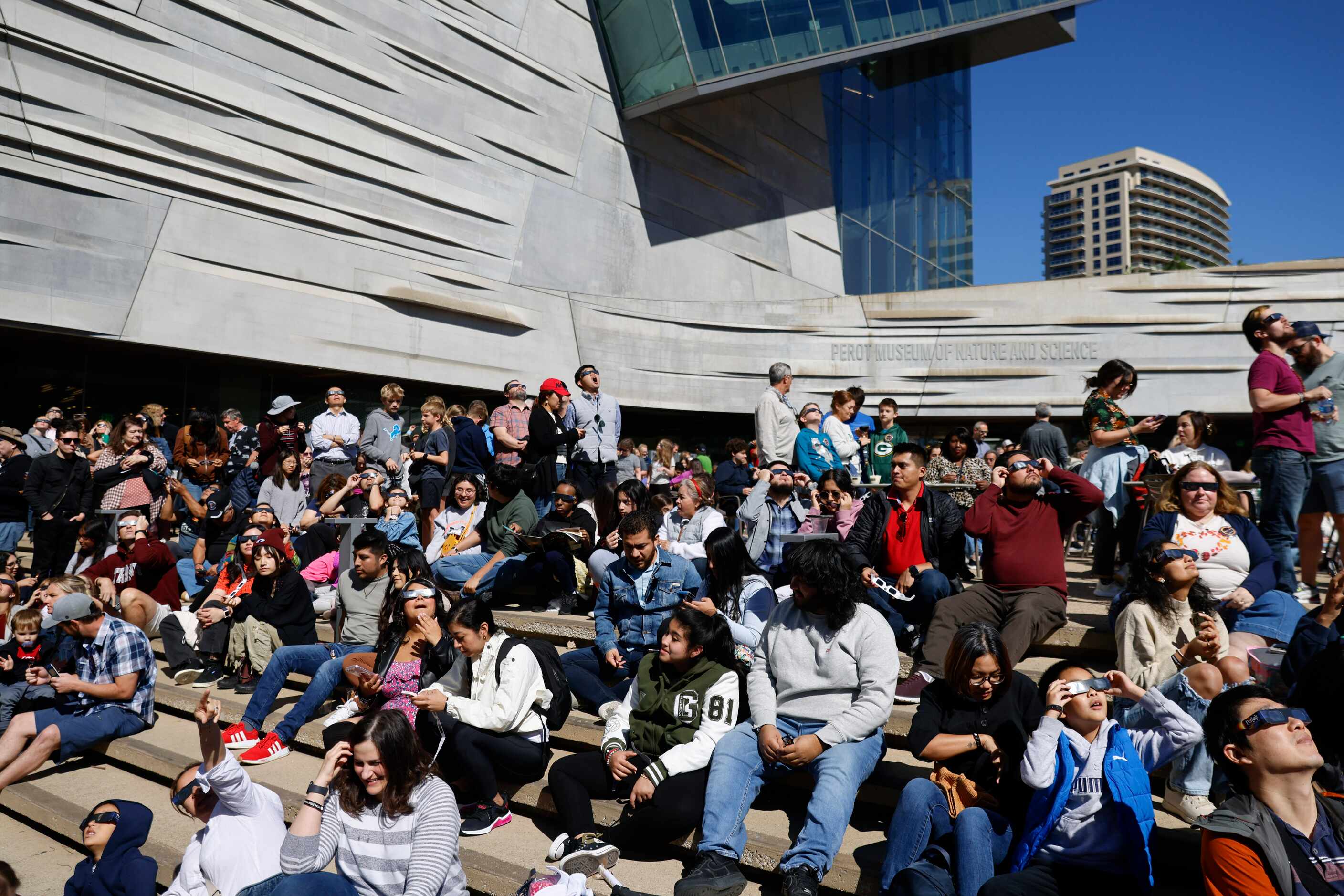 People gather to watch the annular solar eclipse on Saturday, Oct. 14, 2023, at Perot Museum...
