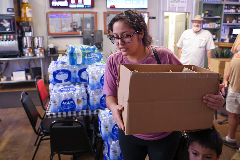 Karina Martinez holding box containing free hamburgers, exits York N Ale, on Monday, May 27,...