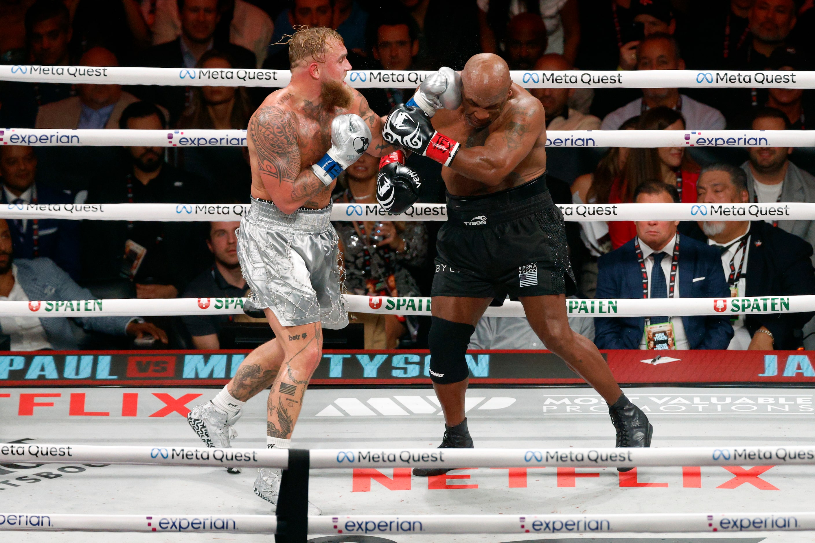 Jake Paul hits Mike Tyson during the seventh round of a heavyweight boxing match, Friday,...