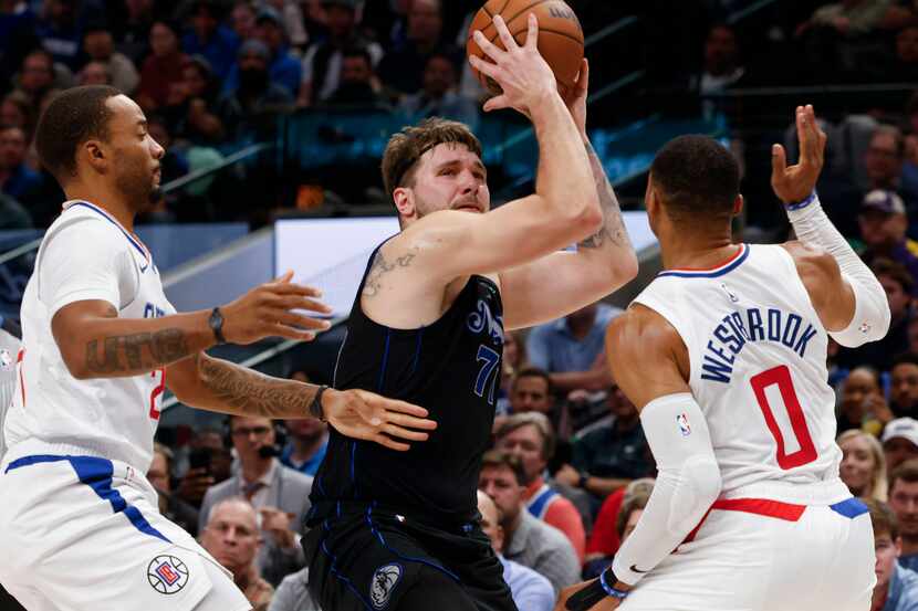 Dallas Mavericks guard Luka Doncic (center) drives to the basket against LA Clippers guard...