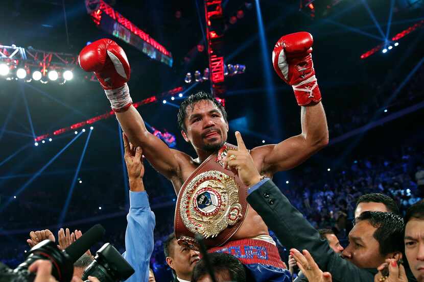 Manny Pacquiao from the Philippines wears the champion's belt after defeating Brandon Rios...