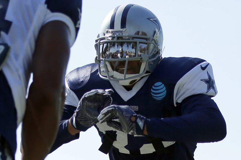 Dallas Cowboys wide receiver Rodney Smith (left) is reflected in the face mask of cornerback...