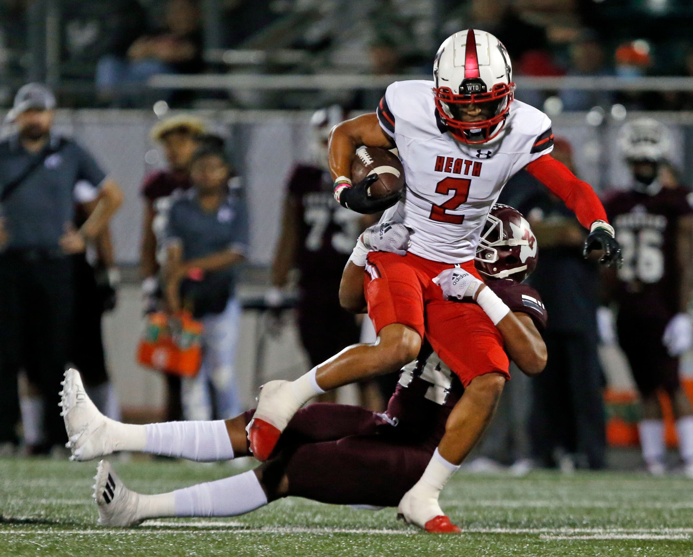 Rockwall Heath WR Jordan Nabors (2) is dragged down by Mesquite defender Tyler Many (44)...