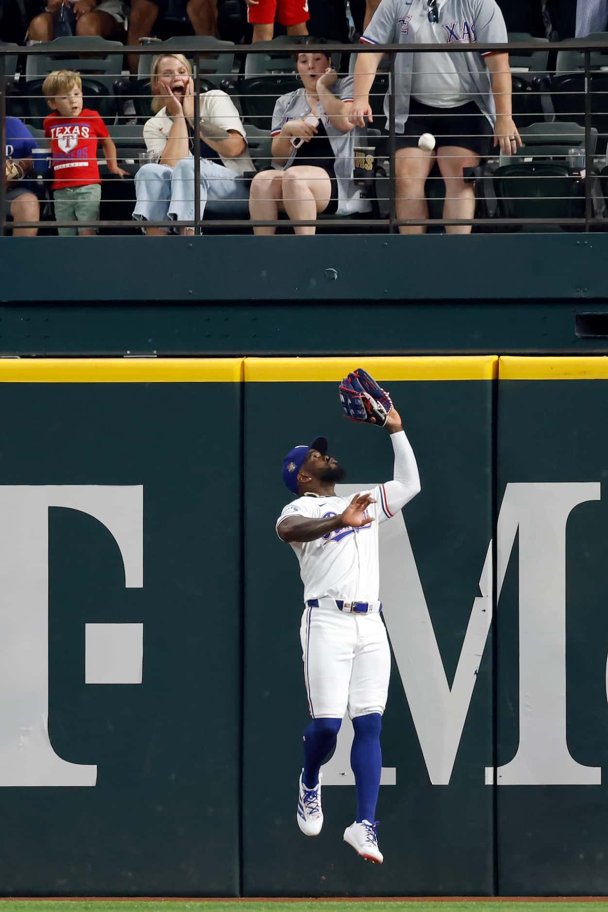 Texas Rangers right fielder Adolis Garcia (53) makes a leaping catch at the wall off the bat...