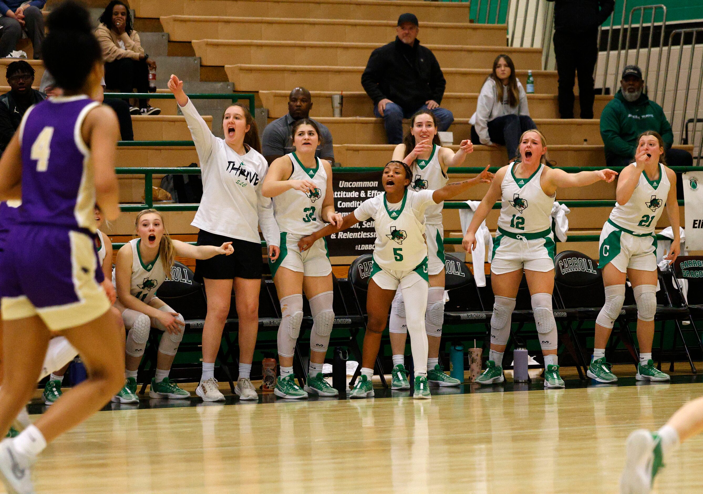 Southlake Carroll’s players cheer during the second half of a high school basketball game...