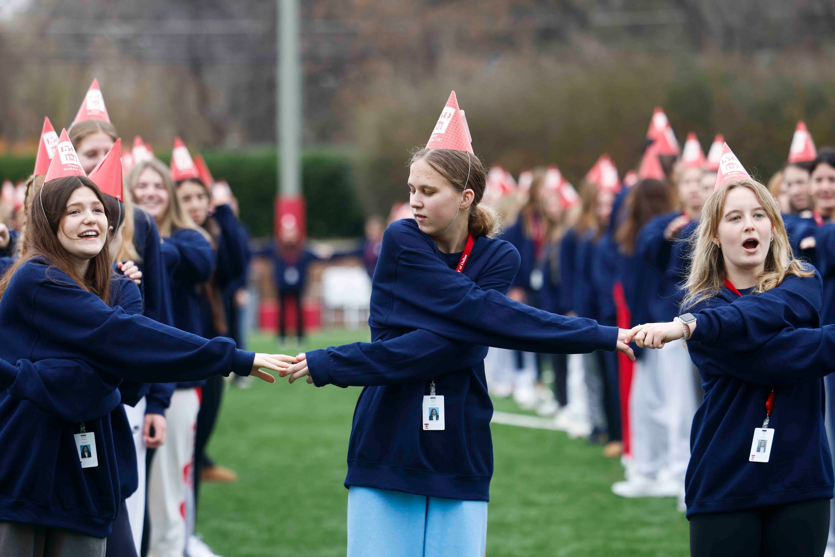 From left, students Amelia Rowes, Peyton Miller, and Isabel Pyle hold hands while preparing...