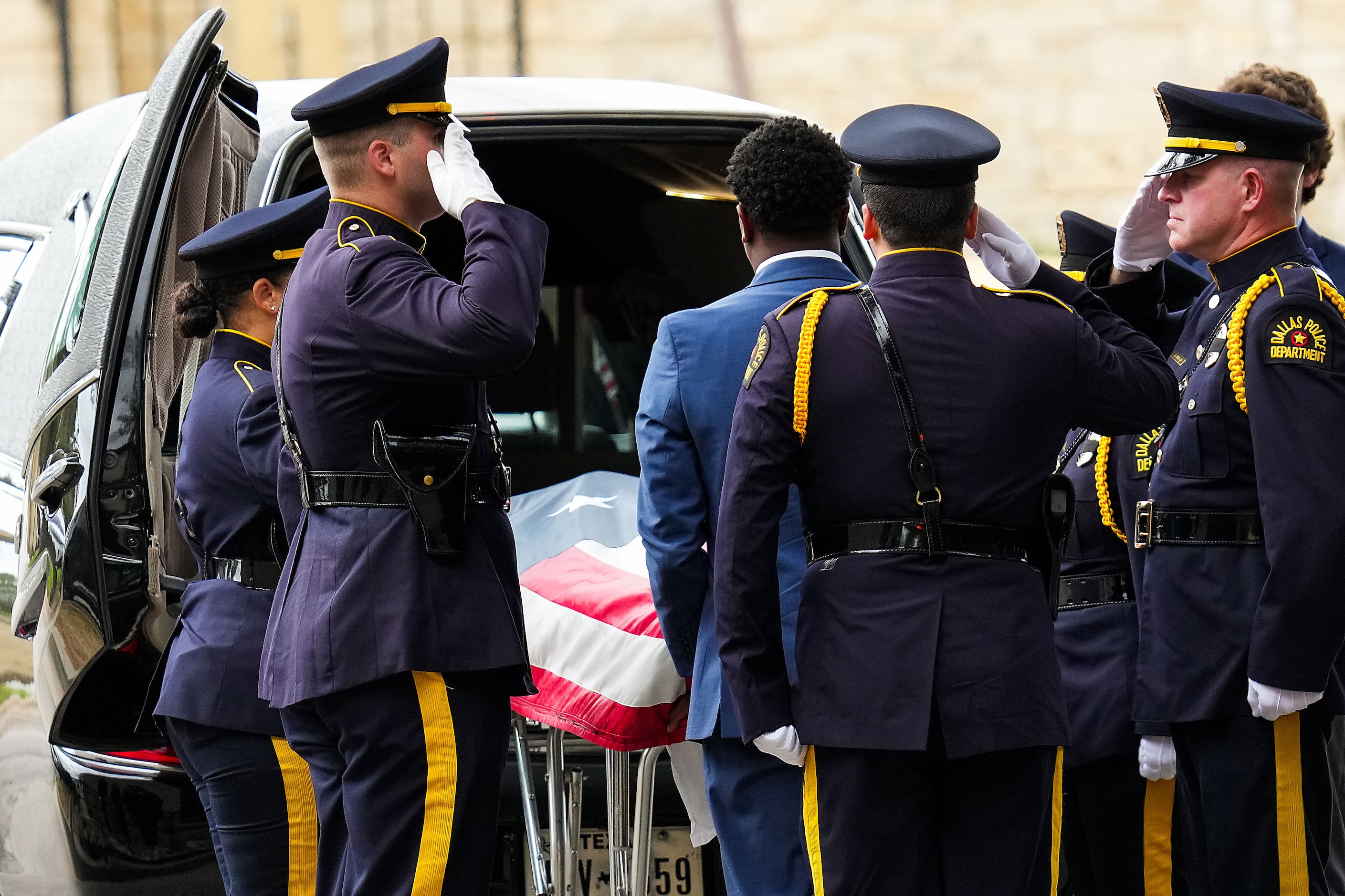 Members of the Dallas Police Honor Guard salute at Restland Funeral Home as fallen officer...