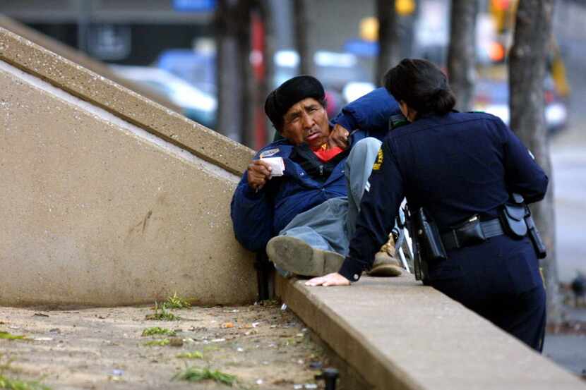 Senior Dallas police officer S. Ortega de King helps a homeless man understand he cannot ...