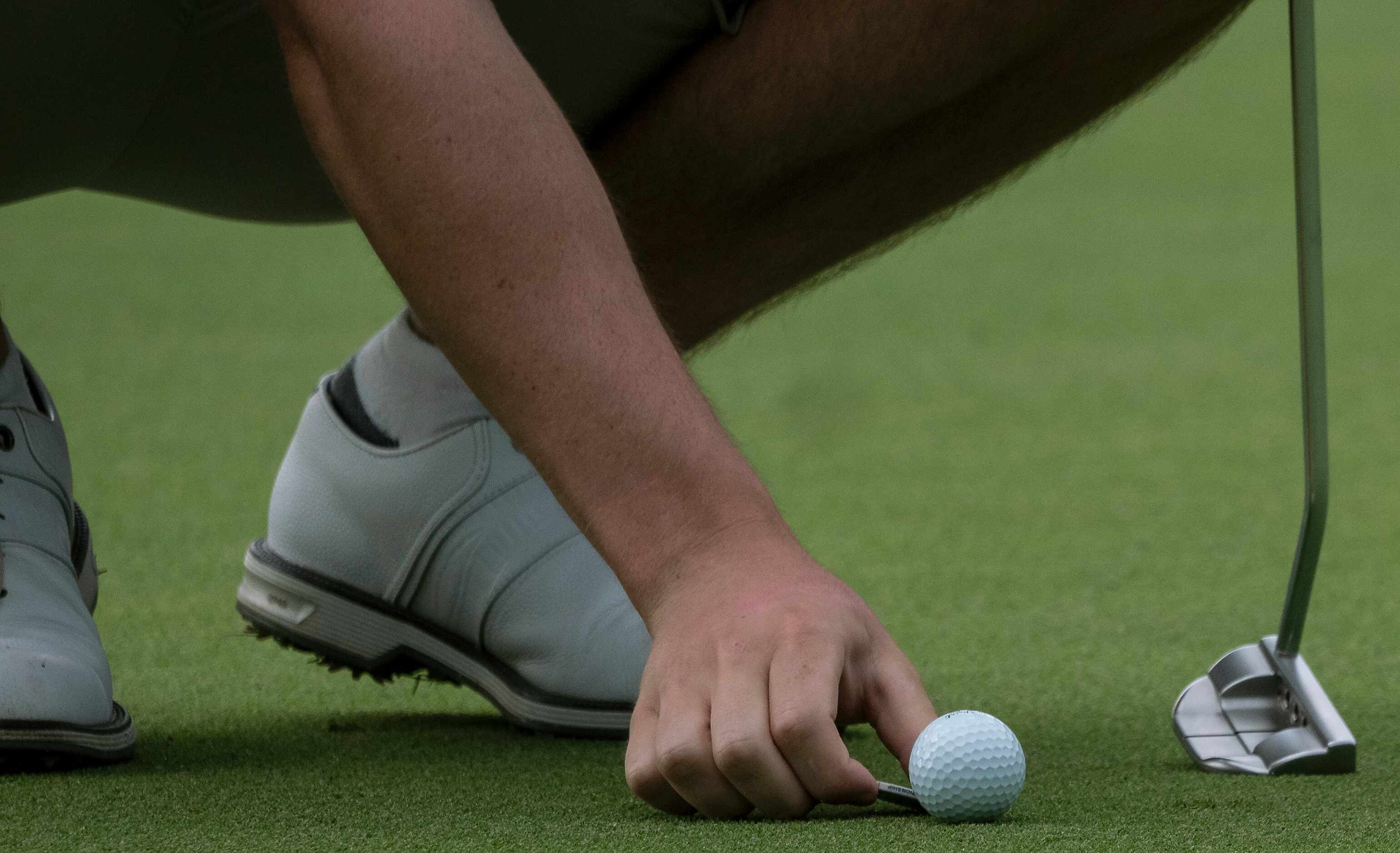 Flower Mound Marcus, Algya Trevor, places his ball down on the marker of the no.1 green...