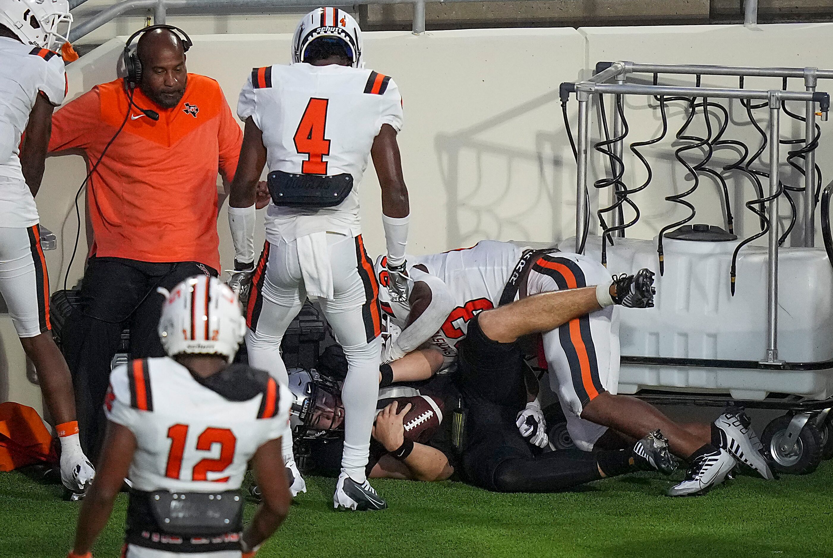 Denton Guyer quarterback Jackson Arnold (11) is driven into the bench area by Lancaster...