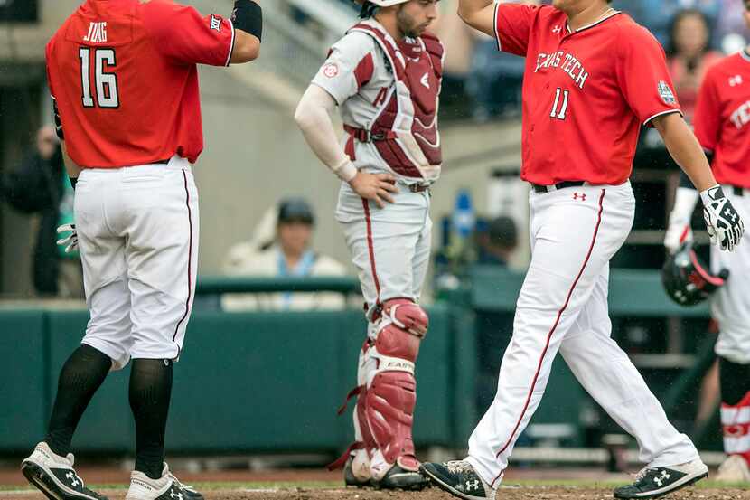 Texas Tech's Cameron Warren, right, celebrates his two-run home run with Josh Jung who also...