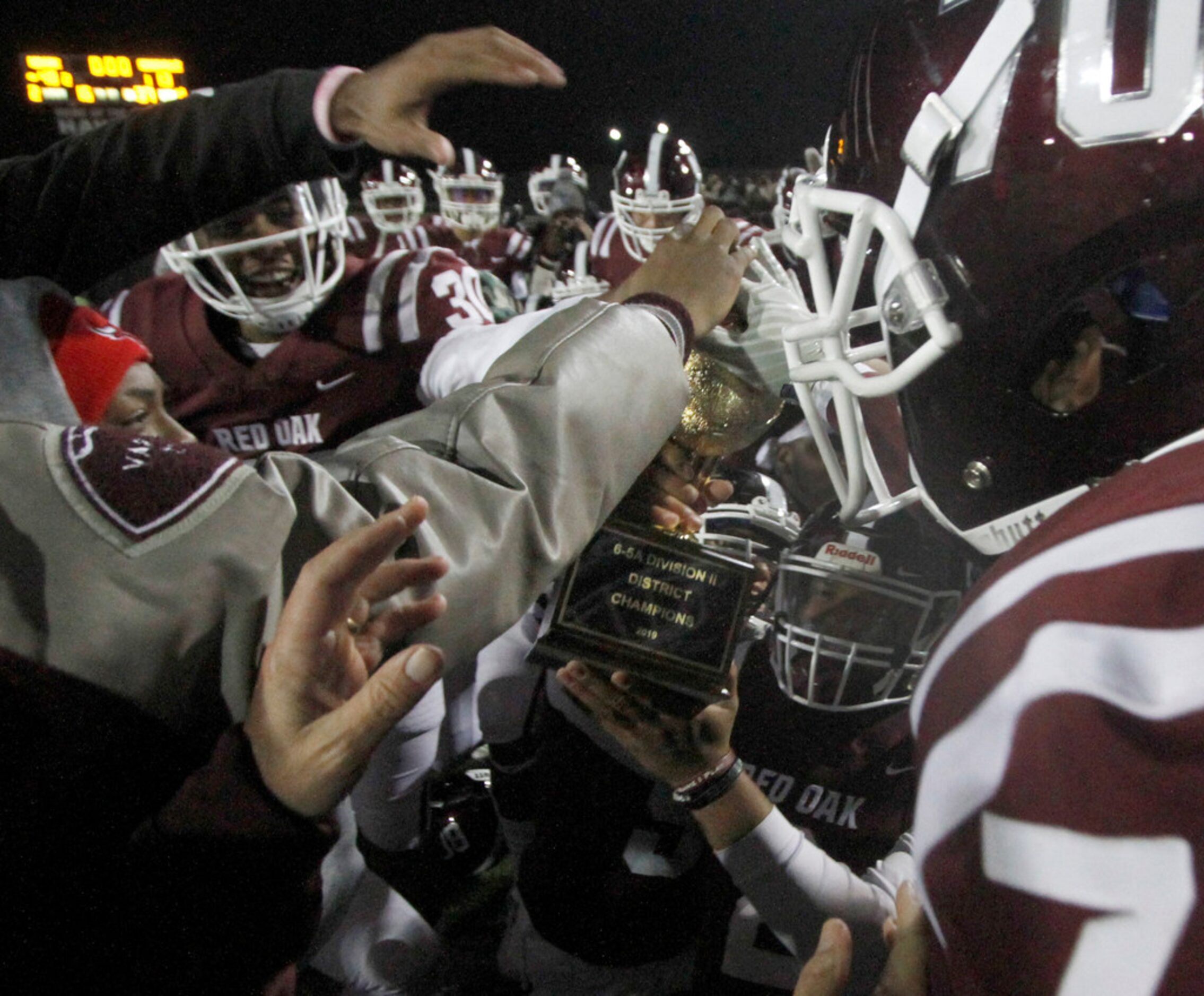 Held by Red Oak quarterback Joshua Ervin (2), the District 6-5A Division ll trophy became...