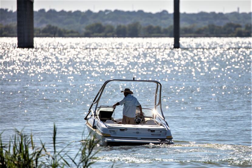 A man operates a boat on Lake Ray Hubbard in Garland, Texas, on Saturday, July 18, 2020.
