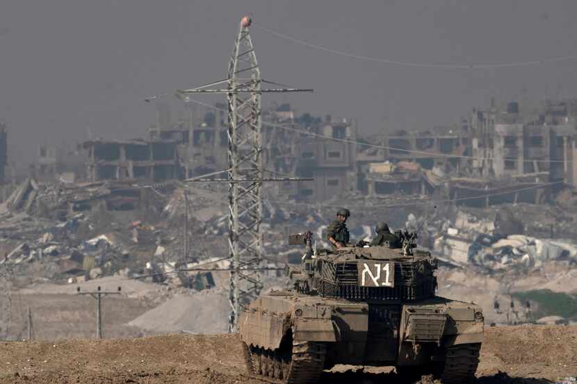 Soldados israelíes observan la Franja de Gaza desde un tanque, vistos desde el Sur de...