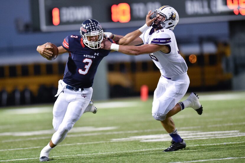 Ryan junior quarterback Spencer Sanders (3) stiff arms Denton senior defensive lineman Eric...