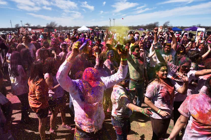 Festival goers dance and toss colored pigments during the celebration of Holi at the Dallas...