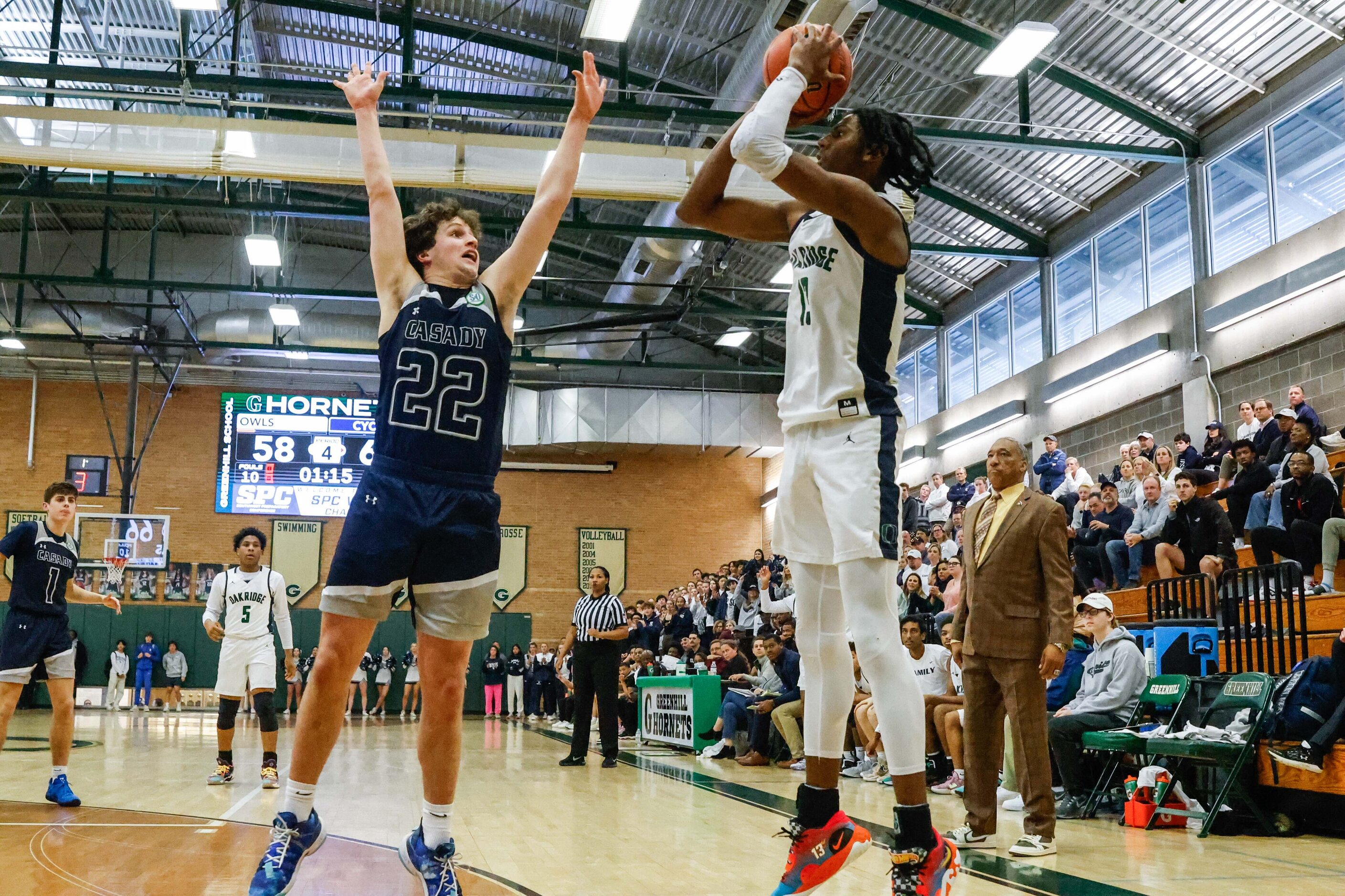 Oakridge Owls' Mitchell Holmes (13) goes for a shot as Casady Cyclones' Davis Currie (22)...