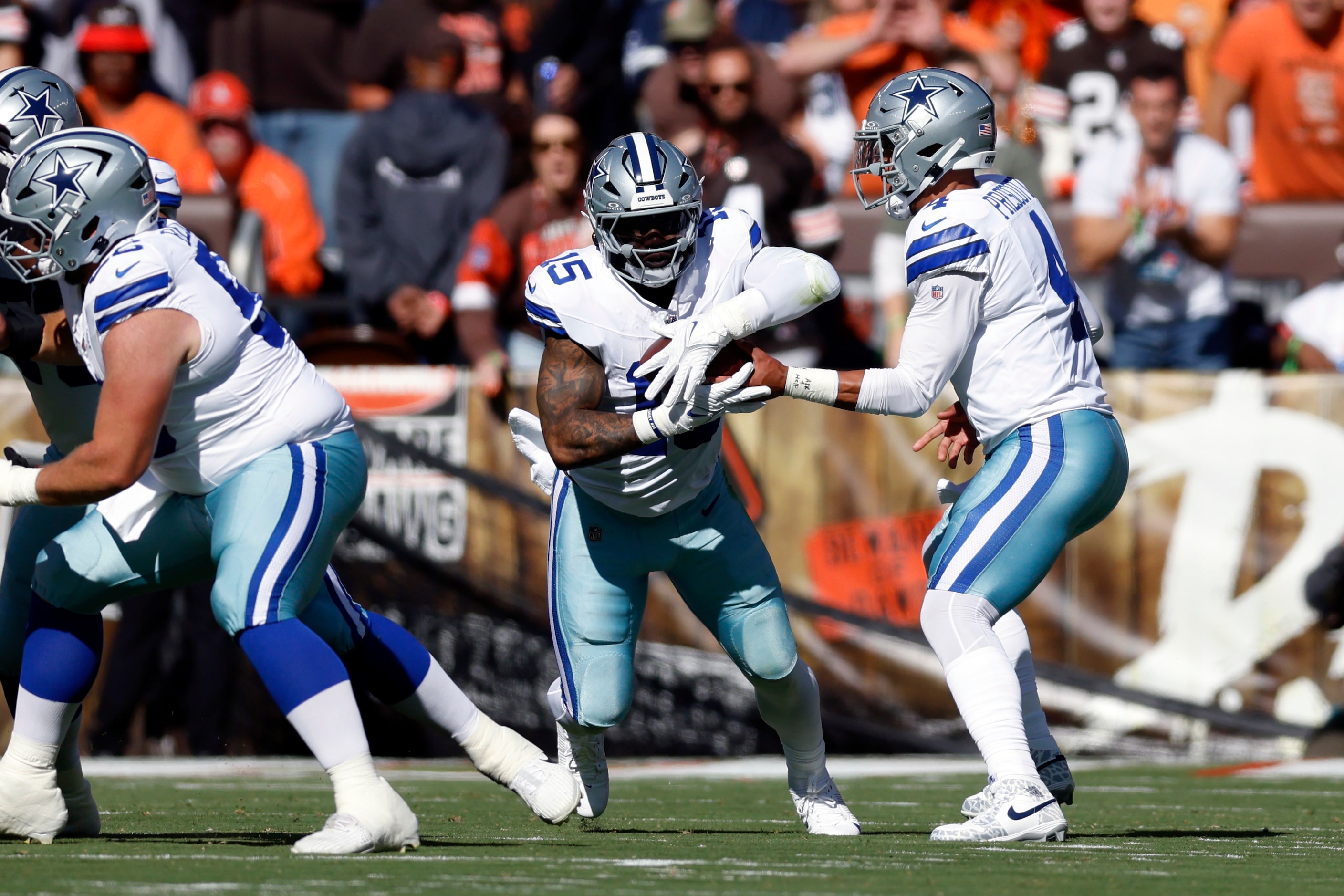 Dallas Cowboys quarterback Dak Prescott (4) hands the ball to running back Ezekiel Elliott...