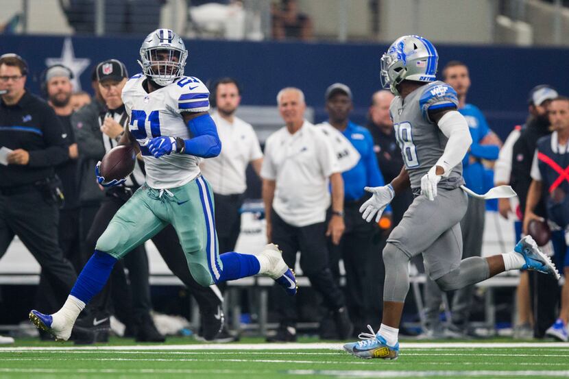 Dallas Cowboys running back Ezekiel Elliott (21) runs the ball ahead of Detroit Lions...