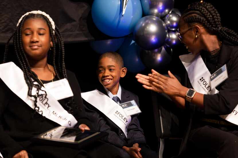 Zihair Douglas (center), a fifth grader at T.L. Marsalis Elementary STEAM Academy, reacts to...