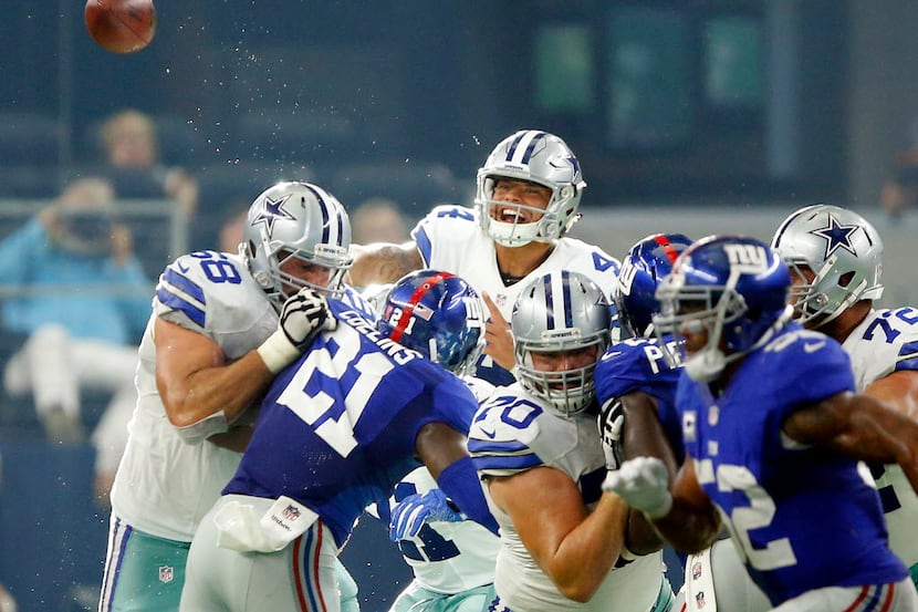 Dallas Cowboys quarterback Dak Prescott (4) tosses a pass over the New York Giants line...