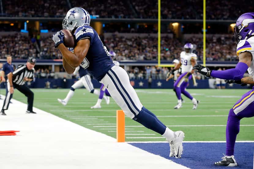 With tow feet down in the end zone, Dallas Cowboys wide receiver Amari Cooper (19) pulls in...