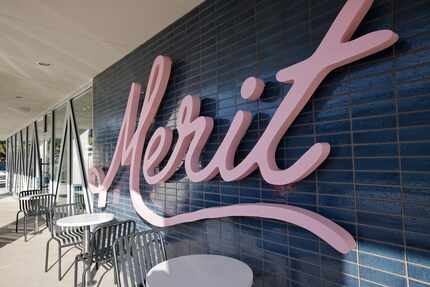 Outside of the coffee shop, a pink sign shows off the Merit logo in Dallas.