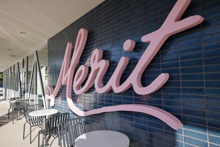 Outside of the coffee shop, a pink sign shows off the Merit logo in Dallas.